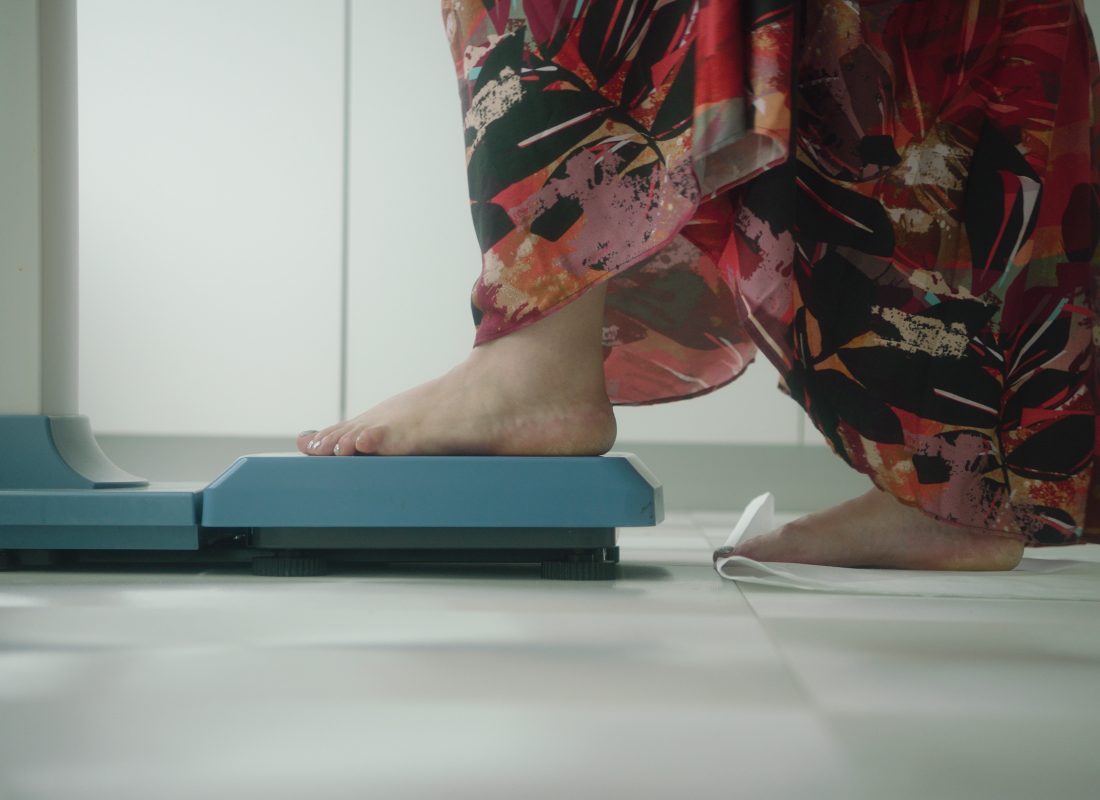 Close up of person stepping on a scale. Still from 'From small steps to systemic shifts' from the Turning the Tide series