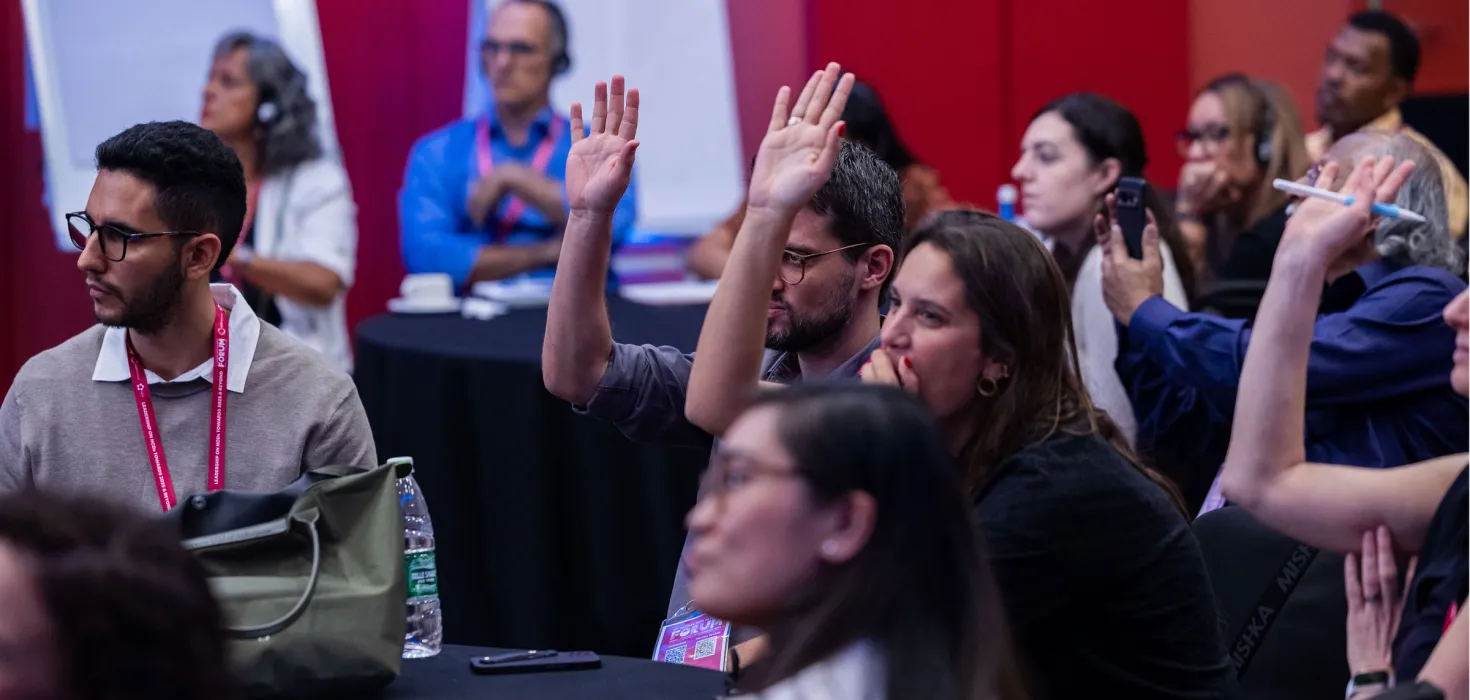 People with hands up at Global NCD Alliance Forum in Kigali 2025