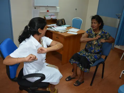 Diabetic Specialist Nurse in Port Louis, Mauritius, teaches a patient simple limb exercises 
