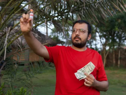 Diabetes activist looks at an insulin bottle in his hand