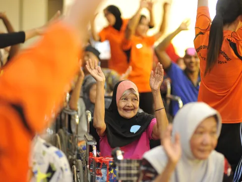 Old people exercising with nurses to maintain good mental and physical health