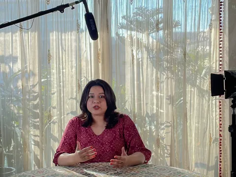 Woman being interviewed with microphone above her head about NCDs