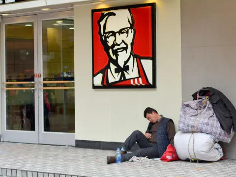 Homeless man lying in front of a KFC in China 