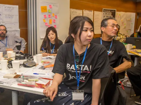 NCD advocates listening to a meeting with black shirts on