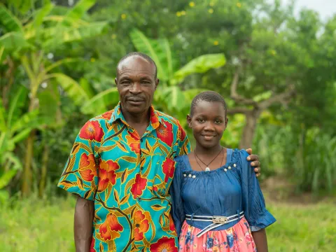 Tasha, leukemia survivor from Uganda, with her grandfather. Still from Facing Forward series