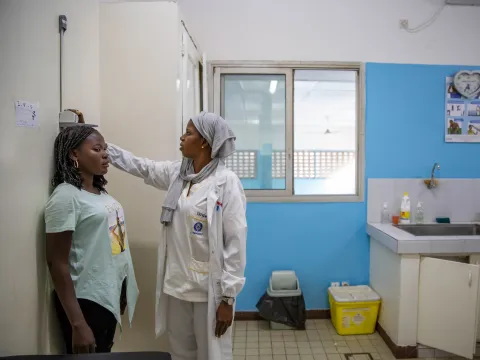 A young woman living with diabetes gets her height measured at a hospital 