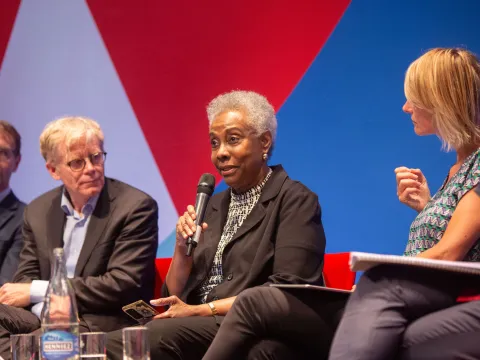 Caribbean woman on stage at NCD Alliance event in Geneva World Health Assembly talking