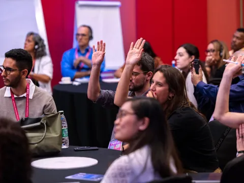 Participants raising their hands at a satellite session at the Global NCD Alliance Forum 2025