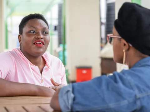 A person living with HIV talks to a friend in Nairobi