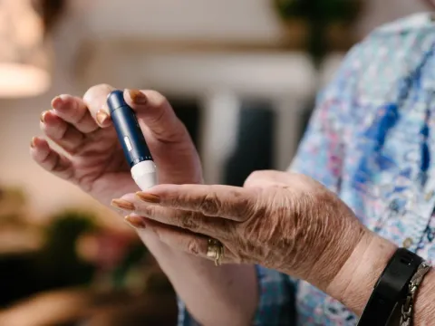 woman taking a sample of her blood using lancet