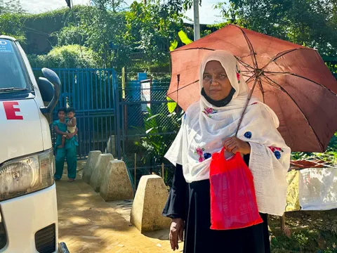 lady in asia sheltering from sun under umbrella