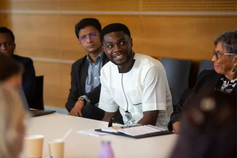 a young black man smiling at a meeting on ncd advocacy in Geneva