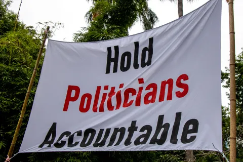 Protest sign with 'hold politicians accountable' on it