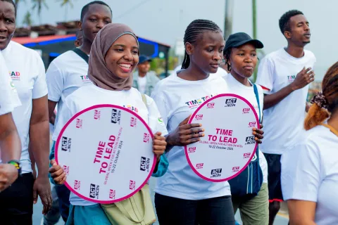 Tanzanian advocates with time to lead on ncds signs smiling during a walk