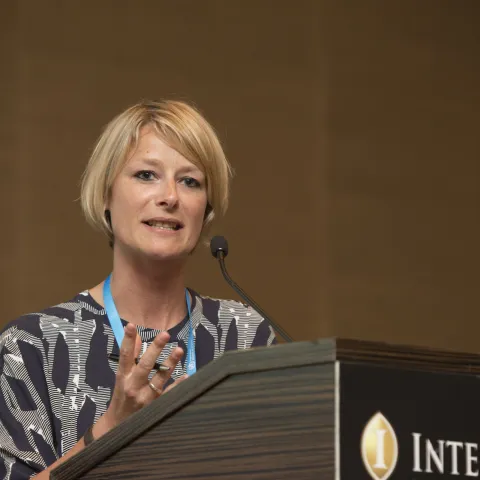NCDA CEO katie dain talking at a lectern at intercontinental geneva