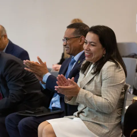 Woman clapping at an NCD Alliance event in new york with smile on face