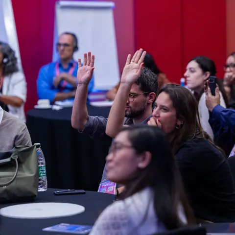 People with hands up at Global NCD Alliance Forum in Kigali 2025