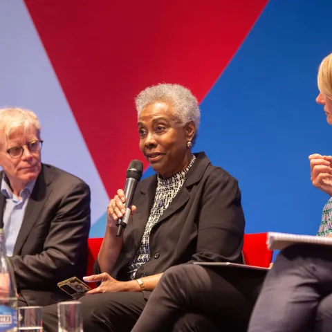 Caribbean woman on stage at NCD Alliance event in Geneva World Health Assembly talking