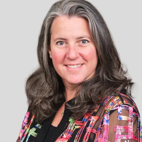 lady smiling for portrait with colourful top on