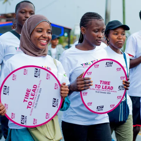 Tanzanian advocates with time to lead on ncds signs smiling during a walk