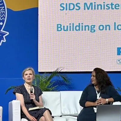 Woman talking on stage as panellist at NCD event